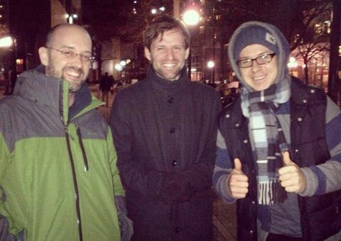 Three people in winter coats smiling