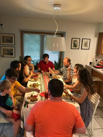 Lab members sitting around a dining table in a house eating