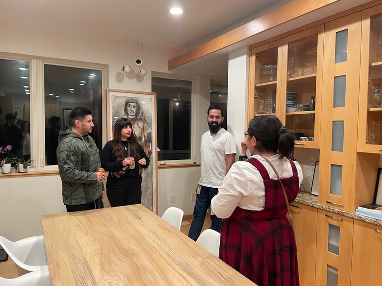 Four people standing around a kitchen island