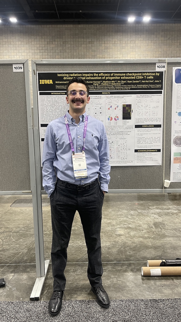 A person standing next to a research poster