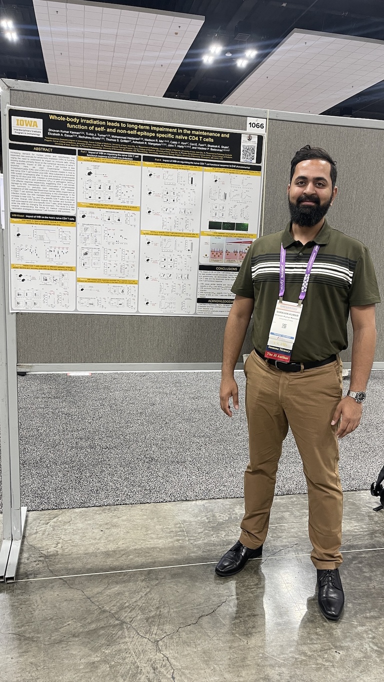 A person standing next to a research poster